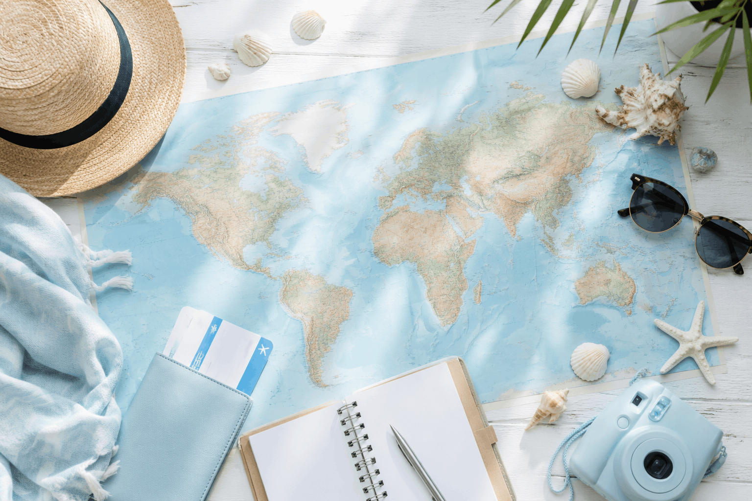 World map, seashells and travel notes on a bright planning desk